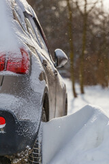 close-up view of car covered with snow and snow drift on its wheel