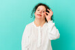 © Asier - Woman with Down syndrome isolated excited keeping ok gesture on eye.