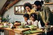 © Drazen - Happy African American family preparing healthy food in the kitchen.