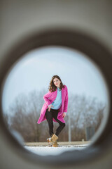 Sticker - Vertical shot of a stylish female wearing a pink coat and posing outdoors