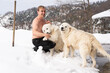 © Dmitrii - Man with a naked torso, two white dogs, snow