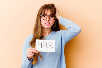 Wall Mural - Young caucasian woman holding a help placard isolated being shocked, she has remembered important meeting.