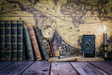 Fototapeta Sawanna - still life composed of antique books, camera and clock on a background of a classic map.