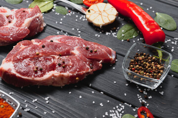 Wall Mural - Raw pork meat with spices and vegetables on wooden table