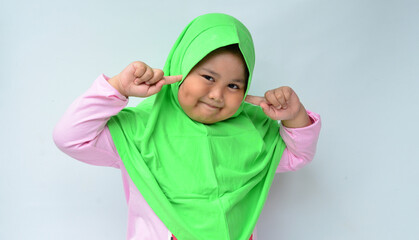 a portrait of an Asian Muslim girl with a cute smiling expression, on a white background