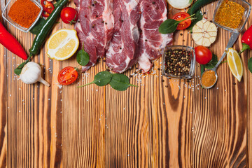 Wall Mural - Raw pork meat with spices and vegetables on wooden table