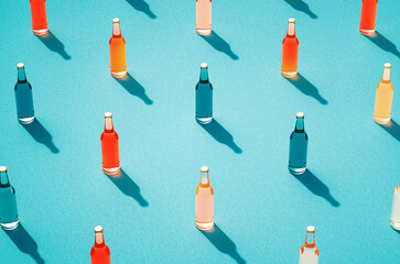 Leinwandbilder - Rows of various color glass bottles against light blue surface.