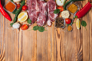 Wall Mural - Raw pork meat with spices and vegetables on wooden table