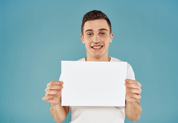 Handsome guy with white sheet of paper advertising mockup Copy Space