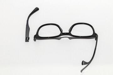 The glasses are damaged, the parts are separated. Focus on the legs of the glasses that have come off.