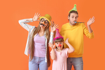 Poster - Young family in funny disguise on color background. April Fools Day celebration