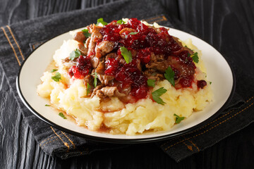 Wall Mural - Portion of homemade venison with mashed potatoes and lingonberry sauce close-up in a plate on the table. horizontal