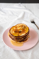 Wall Mural - Homemade Peanut Butter Chocolate Pancakes on a pink plate, low angle view.