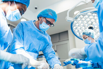 Wall Mural - Surgery operation. Group of surgeons in operating room with surgery equipment. Medical background, selective focus. Surgeon team working together while operation