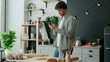 © Grustock - Man surfing in internet using phone standing in kitchen. Portrait of man standing in kitchen and using smartphone