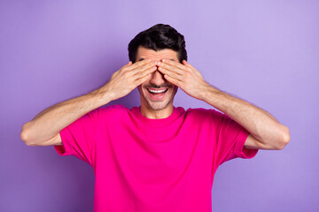 Sticker - Photo of funny playful young man wear pink t-shirt arms cover eyes isolated purple color background