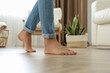 Leinwandbild Motiv Man walking barefoot at home, closeup. Floor heating concept