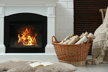 Firewood In Wicker Basket Near Fireplace Indoors