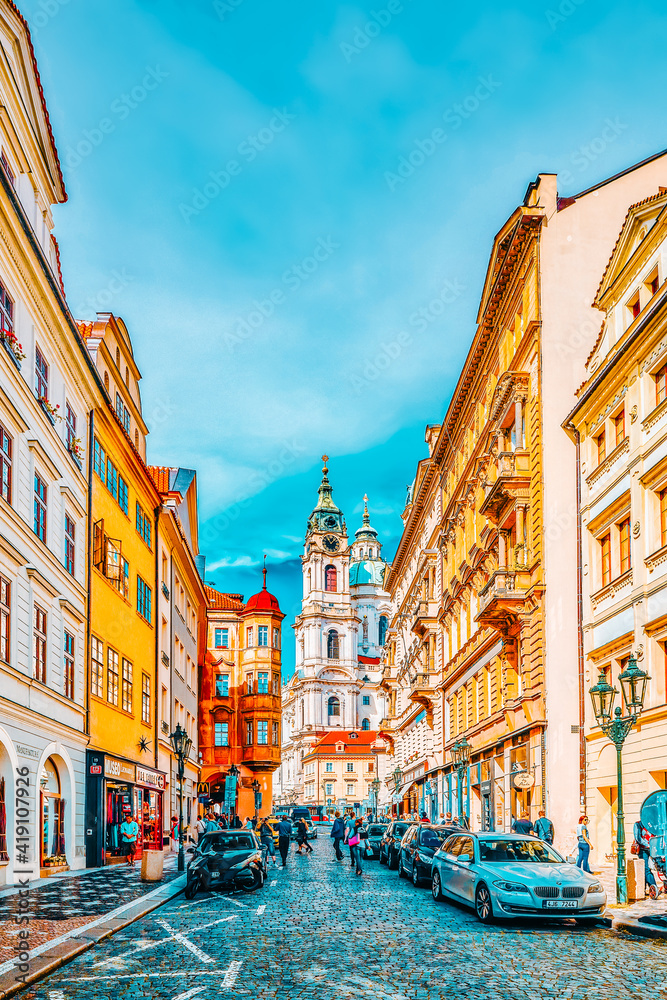 PRAGUE, CZECH REPUBLIC-SEPTEMBER 5, 2015: Malostranske namesti-main square of Prague's Mala Strana(Lesser Town of Prague) and Church of Saint Nicholas is a Baroque church in the Lesser Town of Prague - obrazy, fototapety, plakaty 