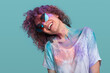 Cheerful hipster woman in sunglasses dancing during Holi party