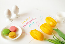 Happy Mother's Day With Beautiful Bouquet Of Yellow And Red Tulips, Eggs, French Macaroni And Card On Green Background, Spring Flowers Flat Lay