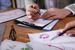 © New Africa - Business people working with charts and graphs at table, closeup. Investment analysis