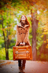 Sticker - Redhead girl with suitcase at autumn outdoor