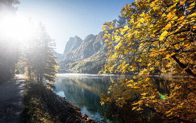 Fototapete - Stunning Autumn Scene. Majestic Mountain lake under sunlight, Gosausee lake during sunset. Amazing Nature Landscape. Awesome natural Background. Great colorful Scenery in fall. Soft light effect
