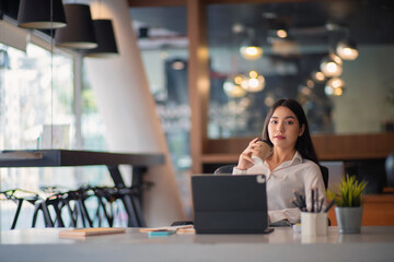 Businesswoman having tea or coffee in home office.