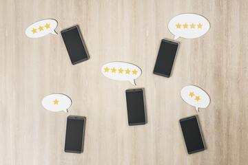 Poster - Rating feedback review concept with black smartphones on wooden surface and stars in speech bubbles