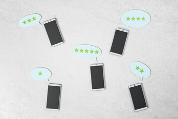 Poster - Rating feedback review concept with black smartphone screens on light concrete surface and stars in speech bubbles