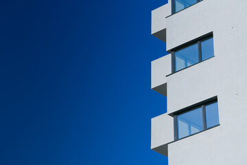 A new flat apartment building close up with clear blue sky in background