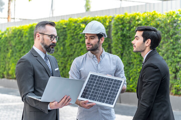 Two Businessman and power engineering talking and checking quality power solar cell with laptop computor on site new project power solution business