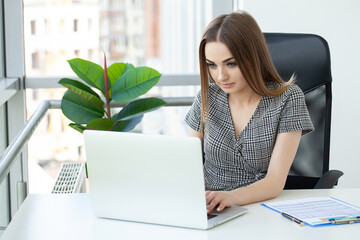 Portrait of a serious businesswoman using laptop in office