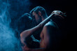 © LIGHTFIELD STUDIOS - Sexy man kissing girlfriend in bra on black background with smoke