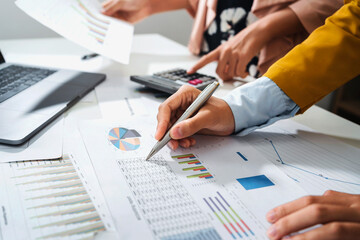 close up hand accountant holding pen pointing on paperwork chart for meeting team in office room. concept finance and accounting