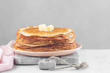 Sticker - Stack of hot crepes with pieces of butter. On white table. Copy space.