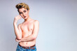 naked shirtless non binary portrait of asian man with luxurious blonde hair and gorgeous make-up in white wall studio background
