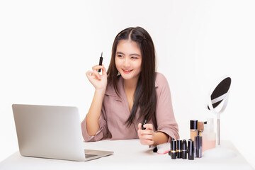 Wall Mural - Young woman make up artist present beauty product, broadcasting live video on social network for sale by using laptop Beauty girl show eyeliner product and offer customer for sale of beauty product