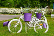old children's bicycles are painted white and used in the street flowerbed as a flower pot holder. reuse of things, the second life of a bicycle.