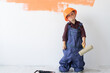 © Andrii Lysenko - a little boy is wearing an orange hard hat and a large jumpsuit. Copy space.