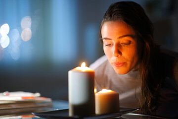 Woman blowing out candles at home in the night