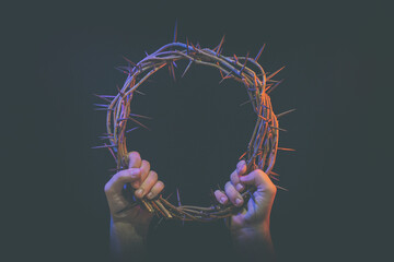 two hands hold crown of thorns