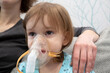 © Yekatseryna - Kid girl makes inhalation with a nebulizer. sick child with mother holding inhalator in hand and breathes through an inhaler at home.