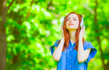 Sticker - Redhead women with headphones in the park.