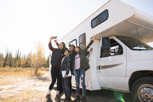 Woman Taking Selfie With Family Next To Motorhome