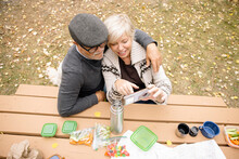 Woman Taking Selfie With Husband At Picnic Table