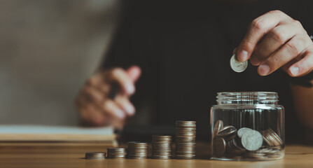 Wall Mural - businessman holding coins putting in glass with using calculator to calculate concept saving money for finance accounting, Business, finance, investment, Financial planning.