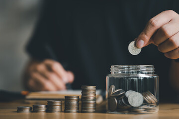 Wall Mural - businessman holding coins putting in glass with using calculator to calculate concept saving money for finance accounting, Business, finance, investment, Financial planning.