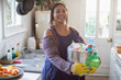© Tom Merton/Caia Image - Portrait smiling woman with cleaning supplies in kitchen